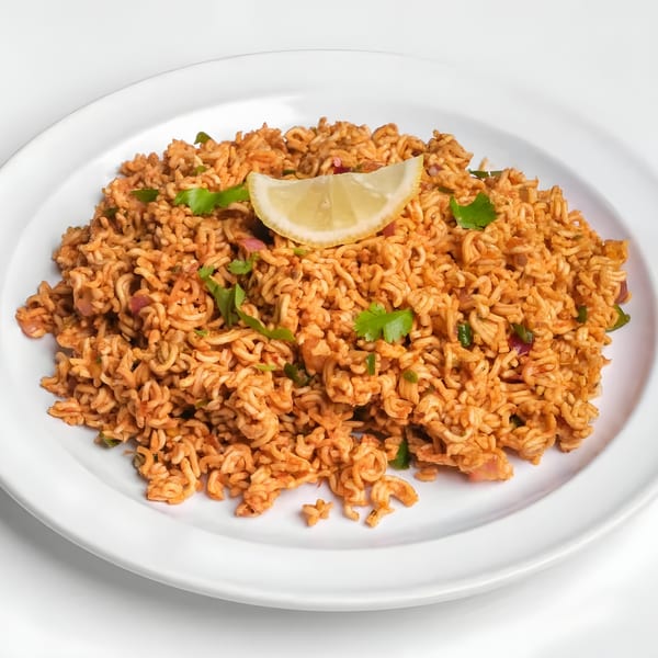 Nepalese Chatpat, a spicy noodle snack with cilantro and a lemon wedge, on a white plate.
