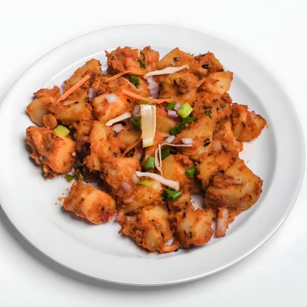 Nepalese Aloo Tikki, spiced potato patties, garnished with onions, carrots, and a lemon wedge.